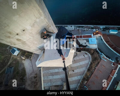 SEVASTOPOL, UKRAINE : UN Adrenaline Junkie a risqué sa vie après l'ascension d'une 195 pieds de haut monument aux héros de guerre russe WW2 juste pour obtenir une nouvelle vidéo de la ville ci-dessous. Vertigo-induisant des images et séquences vidéo montrent le grimpeur audacieux s'emmitoufler d'une échelle à l'intérieur de la spire avant de sortir sur une surface qui est incliné à 45 degrés, sans aucun équipement de sécurité. Le rooftopper promenades le long de la surface inclinée jusqu'à ce qu'il atteint le bord où il est assis et balance ses jambes tout en passant des messages sur son téléphone. C'est le vidéo a été filmé au sommet de l'Obélisque d'Bayonet-Sail Sevastopo dans Banque D'Images