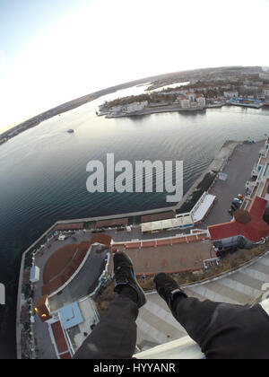 SEVASTOPOL, UKRAINE : UN Adrenaline Junkie a risqué sa vie après l'ascension d'une 195 pieds de haut monument aux héros de guerre russe WW2 juste pour obtenir une nouvelle vidéo de la ville ci-dessous. Vertigo-induisant des images et séquences vidéo montrent le grimpeur audacieux s'emmitoufler d'une échelle à l'intérieur de la spire avant de sortir sur une surface qui est incliné à 45 degrés, sans aucun équipement de sécurité. Le rooftopper promenades le long de la surface inclinée jusqu'à ce qu'il atteint le bord où il est assis et balance ses jambes tout en passant des messages sur son téléphone. C'est le vidéo a été filmé au sommet de l'Obélisque d'Bayonet-Sail Sevastopo dans Banque D'Images