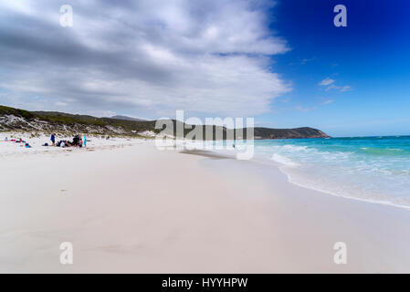 Une plage de sable blanc qui s'étend dans la distance par le côté de bleu de l'océan avec des petits blancs au clapotis des vagues à la plage Plage grinçante Banque D'Images