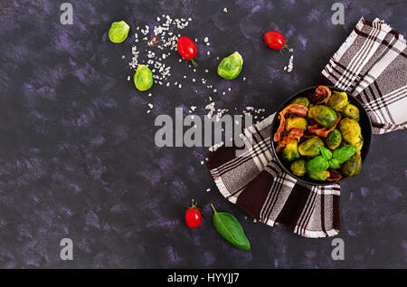 Choux de Bruxelles aux lardons grillés sur fond sombre. Vue d'en haut Banque D'Images