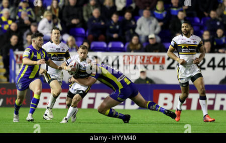 Leeds Rhinos' Rob Burrow (à gauche) est abordé par Warrington Wolves' Chris Hill au cours de la Super League Betfred match au stade Halliwell Jones, Warrington. Banque D'Images