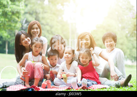 Belle asiatique générations multiples portrait de famille, grands-parents, parents et enfants, piscine nature park en matin avec sun flare. Banque D'Images