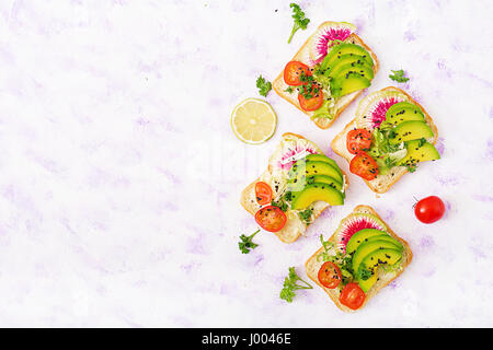 Sandwiches vegan avec avocat, radis pastèque et les tomates sur un fond blanc. Mise à plat. Vue d'en haut Banque D'Images