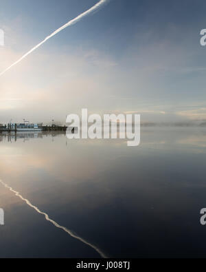 La brume s'élève de ses eaux calmes du lac Windermere, à Ambleside Pier en Angleterre's Lake District National Park. Banque D'Images