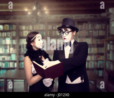 Deux artistes de théâtre pantomime posant avec un livre. Mime acteur et actrice effectuant Banque D'Images