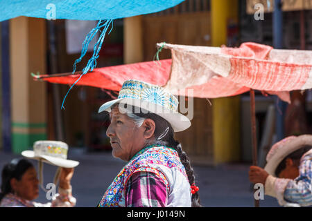 Femme de local de cochon tressés en bleu traditionnel chapeau brodé avec rosette, Chivay, la vallée de Colca, Caylloma province, région d'Arequipa, Pérou Banque D'Images