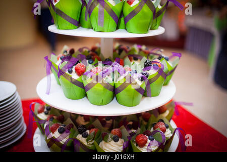 Mini cupcakes sur un multi niveau tier dans différentes couleurs Banque D'Images