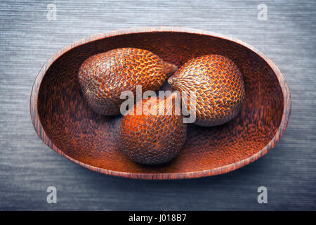 Serpent salak ou des fruits dans une plaque de bois Banque D'Images