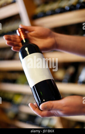 Une étiquette pour être en mesure d'écrire leur propre,mains tenant une bouteille de vin, wineshop, Carlsbad, République Tchèque Banque D'Images
