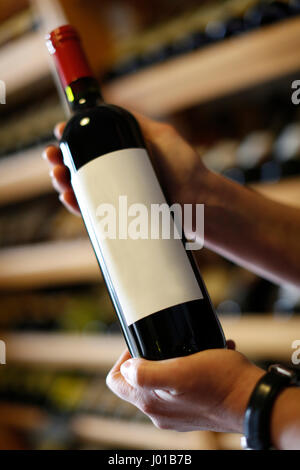 Une étiquette pour être en mesure d'écrire leur propre,mains tenant une bouteille de vin, wineshop, Carlsbad, République Tchèque Banque D'Images