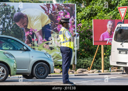 Victoria, Mahe, Seychelles - 16 décembre 2015 : une femme creole police woman contrôle du trafic dans la ville de Victoria dans l'île de Mahé dans la republ Banque D'Images