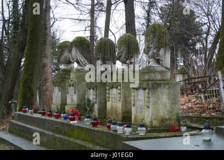 LVIV, UKRAINE - 6 janvier 2014 : Une allée au cimetière Lychakiv (Lviv, Ukraine) et de pierres tombales anciennes recouverts de mousse sur l'hiver de pluie jour. Banque D'Images