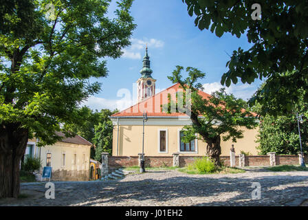 SZENTENDRE, HONGRIE - le 26 juillet 2016 : maison ancienne avec des tuiles du toit et une église dans le centre de Szentendre, petite ville touristique près de Budapest, Hongrie. Banque D'Images