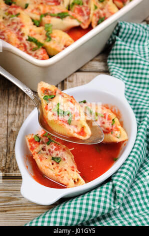 Conchiglioni farcis coquilles de pâtes aux épinards hachis de viande et de la sauce tomate , fromage Parmesan, sur une assiette. Vue de dessus. Banque D'Images