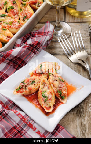 Conchiglioni farcis coquilles de pâtes aux épinards hachis de viande et de la sauce tomate , fromage Parmesan, sur une assiette. Vue de dessus. Banque D'Images