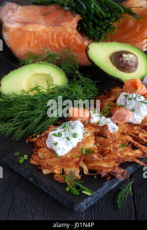 Les galettes de pommes de terre traditionnelle juive latke garnie de saumon fumé, fromage à la crème, l'aneth et la ciboulette. Banque D'Images