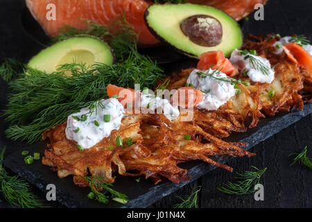 Les galettes de pommes de terre traditionnelle juive latke garnie de saumon fumé, fromage à la crème, l'aneth et la ciboulette. Banque D'Images