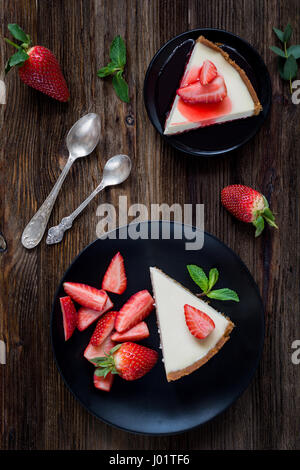 Gâteau au fromage aux fraises sur la plaque noire sur fond de bois rustique. Vue d'en haut Banque D'Images