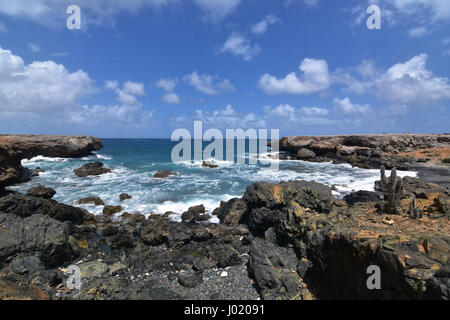 Belle vue sur la plage en pierre de sable noir sur la côte est de l'Aruba. Banque D'Images