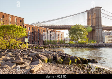 Rivière vue comme le soleil se couche derrière le pont de Brooklyn (USA) Banque D'Images