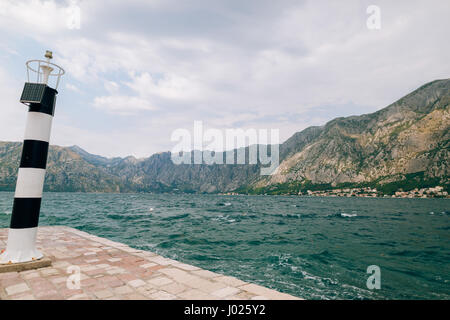 Phare noir et blanc dans la mer. Prcanj, baie de Kotor, Monténégro. Banque D'Images