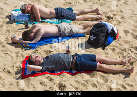 Bournemouth, Dorset, UK. Apr 9, 2017. Météo France : belle chaude journée ensoleillée comme visiteurs chef de la mer à profiter du soleil sur les plages de Bournemouth. Le milieu de journée et les plages sont très occupés ! Trois jeunes hommes à bronzer sur la plage Crédit : Carolyn Jenkins/Alamy Live News Banque D'Images