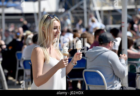 Brighton, UK. Apr 9, 2017. Une jeune femme avec deux glaces comme elle marche sur la plage de Brighton qui est emballé sur la journée la plus chaude de l'année avec des températures atteignant 24 degrés celsius dans certaines régions du pays Crédit : Simon Dack/Alamy Live News Banque D'Images