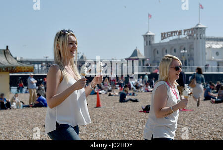 Brighton, UK. Apr 9, 2017. Une jeune femme avec deux glaces comme elle marche sur la plage de Brighton qui est emballé sur la journée la plus chaude de l'année avec des températures atteignant 24 degrés celsius dans certaines régions du pays Crédit : Simon Dack/Alamy Live News Banque D'Images