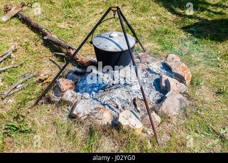 La cuisson des aliments sur un feu de camp en plein air en été journée ensoleillée Banque D'Images