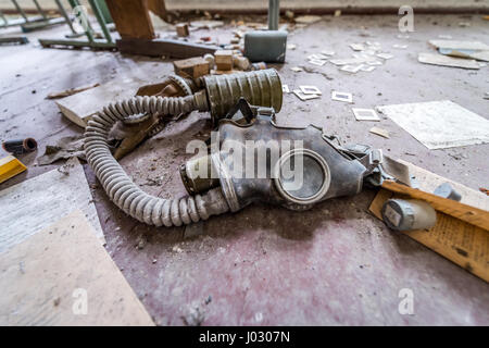 Masque à gaz dans la vieille école secondaire en Mashevo village abandonné de centrale nucléaire de Tchernobyl en Ukraine, la zone d'Aliénation Banque D'Images