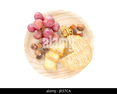 Soft croûte lavée, noisettes, noix et raisins rouges sur la planche de bois texturés top view isolated on white Banque D'Images
