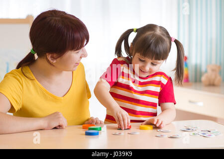 Jeune femme joue avec kid jeu éducatif Banque D'Images