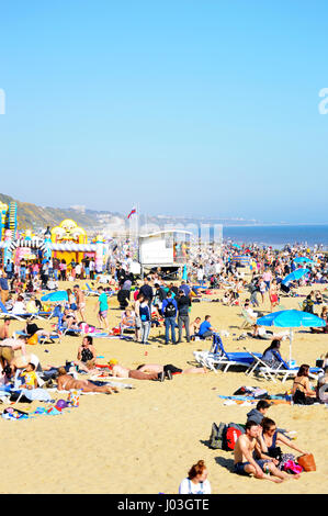 Les gens en train de bronzer sur la plage de Bournemouth encombré par une chaude journée d'avril, Dorset, UK Banque D'Images