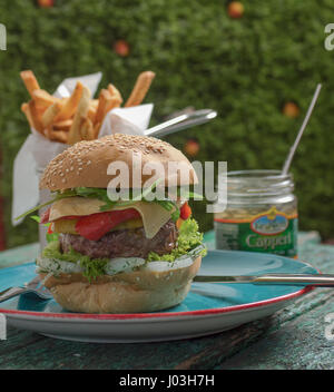 Cheese burger avec frites et les câpres sur green grunge background Banque D'Images