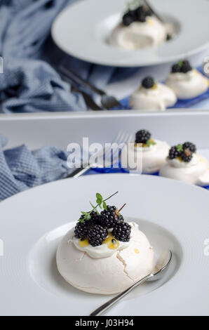 Pavlova dessert avec des fruits de la passion et de fruits sauvages. Des couleurs pastel. Banque D'Images