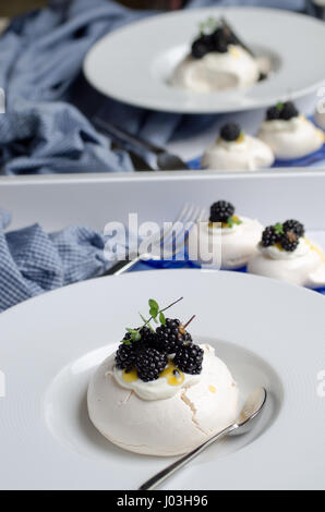 Pavlova dessert avec des fruits de la passion et de fruits sauvages. Des couleurs pastel. Banque D'Images