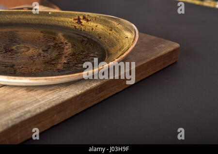 Plaque ronde rustique vide close up avec fond noir Banque D'Images