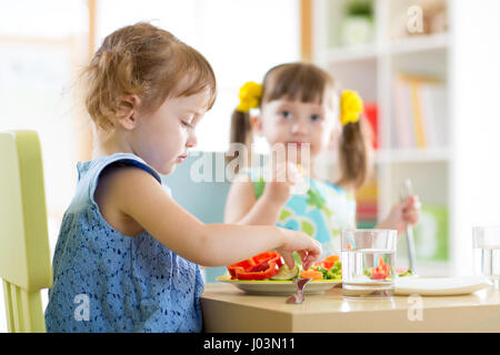 Les enfants Les enfants manger des légumes dans le jardin ou à la maison Banque D'Images