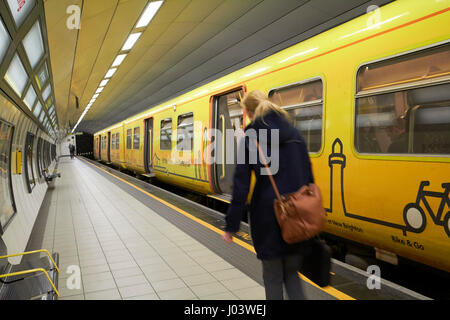 Femme seule merseyrail d'embarquement des passagers en train la gare de métro James Street Liverpool UK Banque D'Images