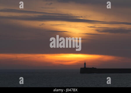 Coucher du soleil Ciel et nuages sur Newhaven phare, East Sussex. Banque D'Images