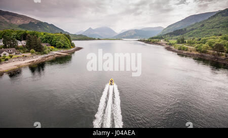 Un bateau passe par le passage sous le pont Ballachulish à travers l'embouchure du Loch Leven prise d'eau de mer sur la côte ouest de l'Écosse, avec Pap de Banque D'Images