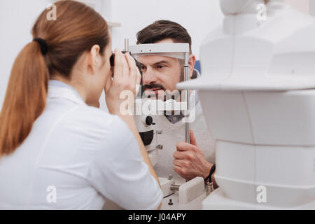 Médecin femme agréable test de la vision de son patient Banque D'Images