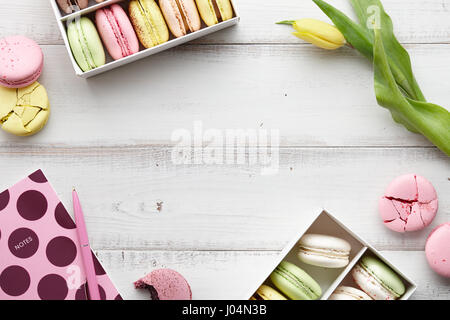 Espace de travail féminin avec ses macarons et tulipes Banque D'Images