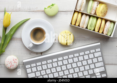 Espace de travail féminin avec ses macarons et tulipes Banque D'Images