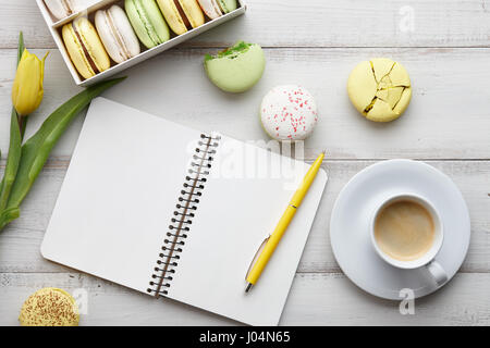 Espace de travail féminin avec ses macarons et tulipes Banque D'Images