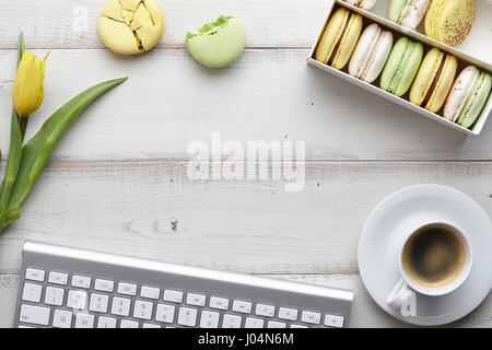 Espace de travail féminin avec ses macarons et tulipes Banque D'Images