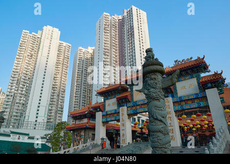 Chinois traditionnel orné Gateway contraste avec l'horizon de Hong Kong sur le Temple de Wong Tai Sin, Hong Kong. Banque D'Images
