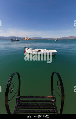 Pier Steps, bateaux de pêche traditionnels et forteresse Bourtzi dans l'arrière-plan lointain de Nafplion, Grèce- portrait photo Banque D'Images