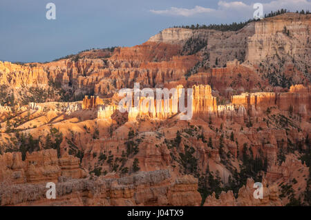 Les rayons du soleil d'abord le début du jour pour éclairer certaines parties de l'Utah Bryce Canyon. Banque D'Images