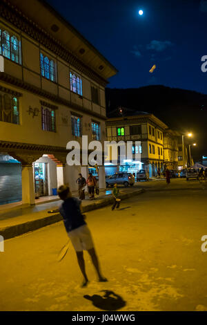 PARO, BHOUTAN - CIRCA Octobre 2014 : les enfants jouer au badminton dans les rues de Paro dans la nuit. Banque D'Images